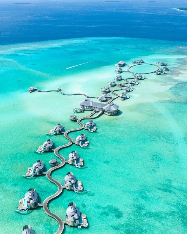 Overwater villas winding across a Maldives lagoon