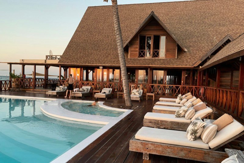 Resort pool deck with loungers at dusk